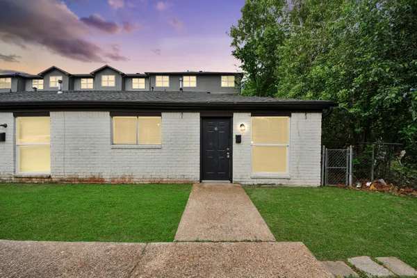 a front view of a house with a garden and yard