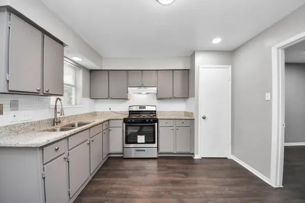 a kitchen with stainless steel appliances granite countertop a sink stove and refrigerator