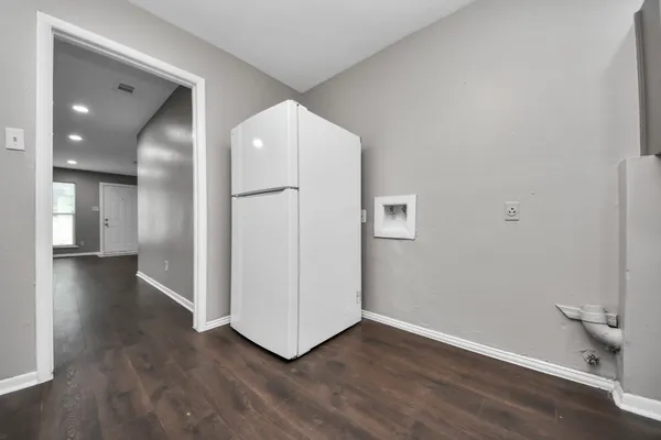 a view of a kitchen with wooden floor and electronic appliances