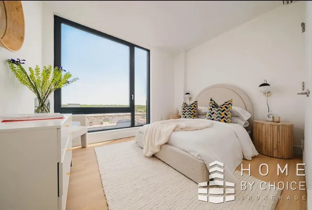 a bedroom with a bed a mirror and a potted plant