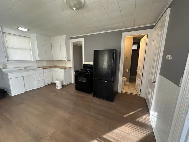 a large kitchen with a refrigerator and a sink