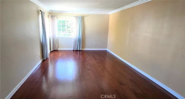 an empty room with wooden floor and cabinet