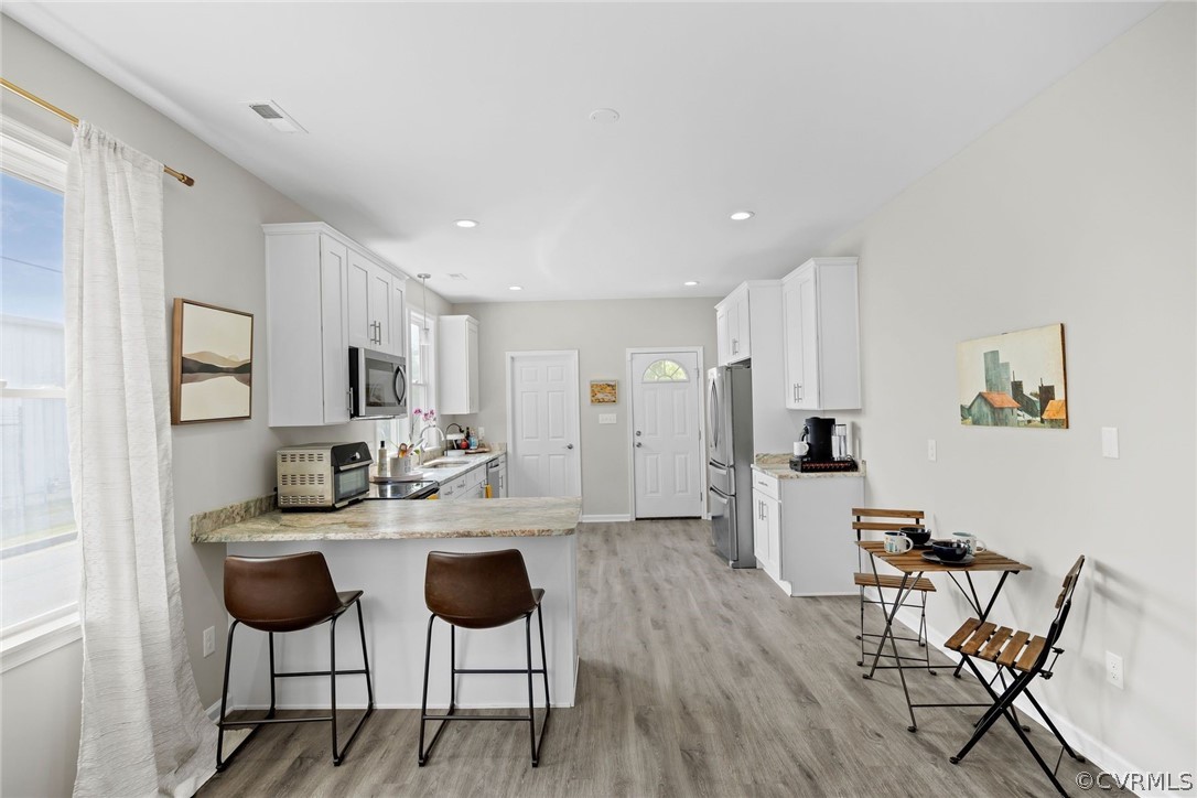 2900 Decatur Street Richmond, VA 23224 - Photo 10 of 35 a kitchen with stainless steel appliances kitchen island granite countertop a dining table chairs and a refrigerator