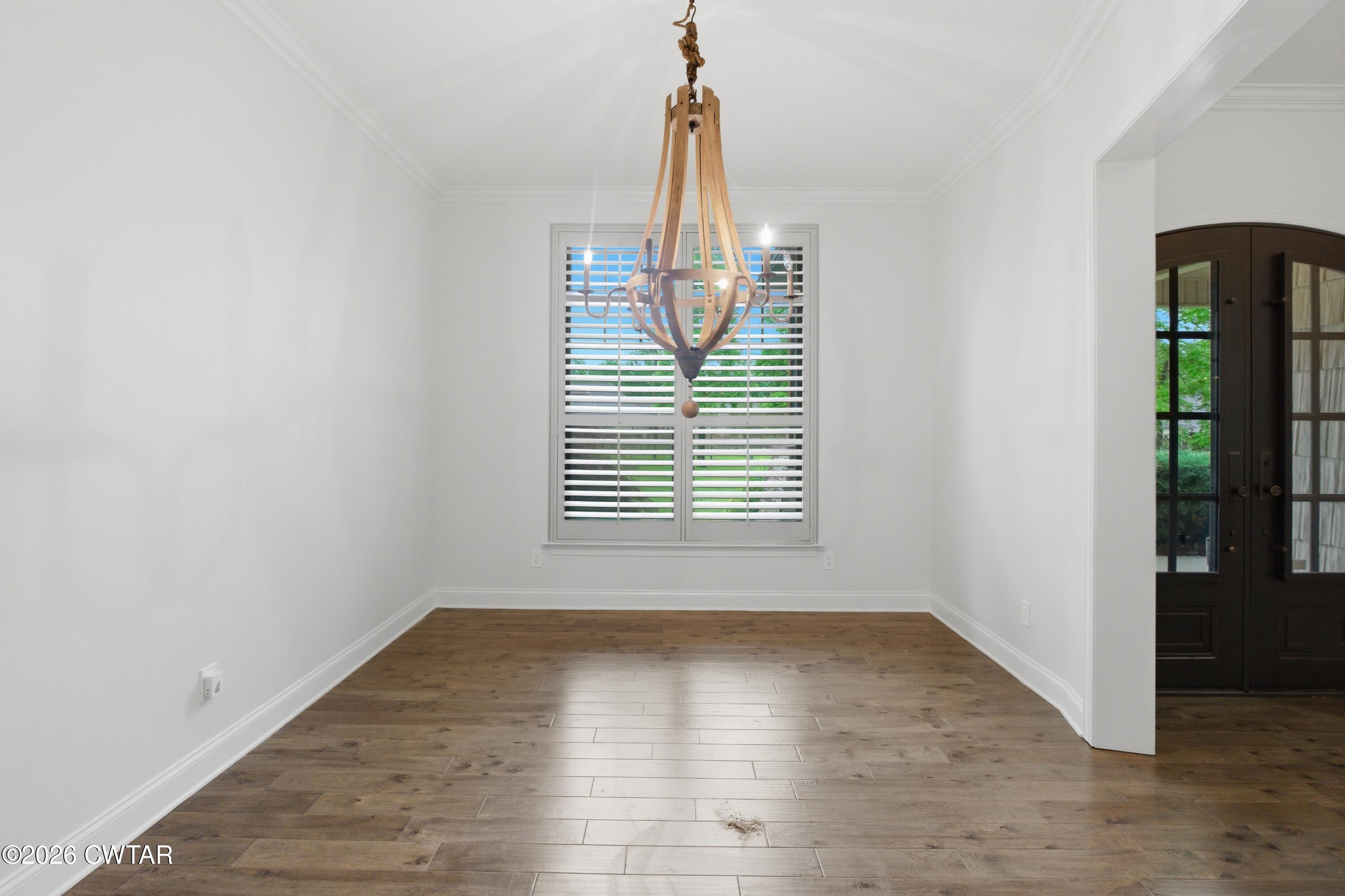 963 Ashport Road Jackson, TN 38305 - Photo 19 of 60 an empty room with wooden floor and windows