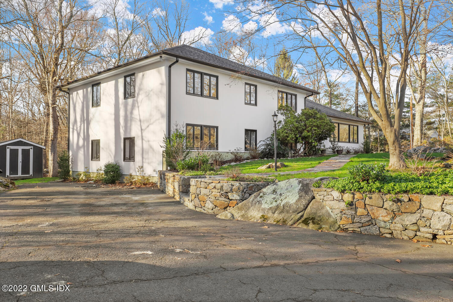 442 Riversville Road Greenwich, CT 06831 - Photo 26 of 29 a view of a white house with a yard and plants