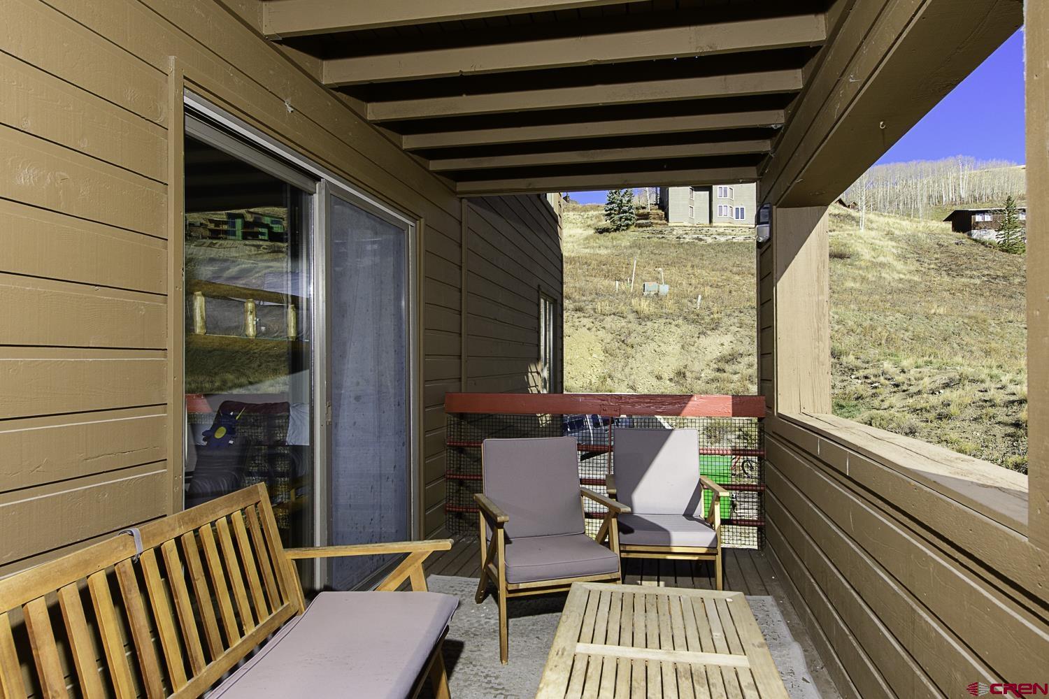 a view of a balcony with furniture and wooden floor
