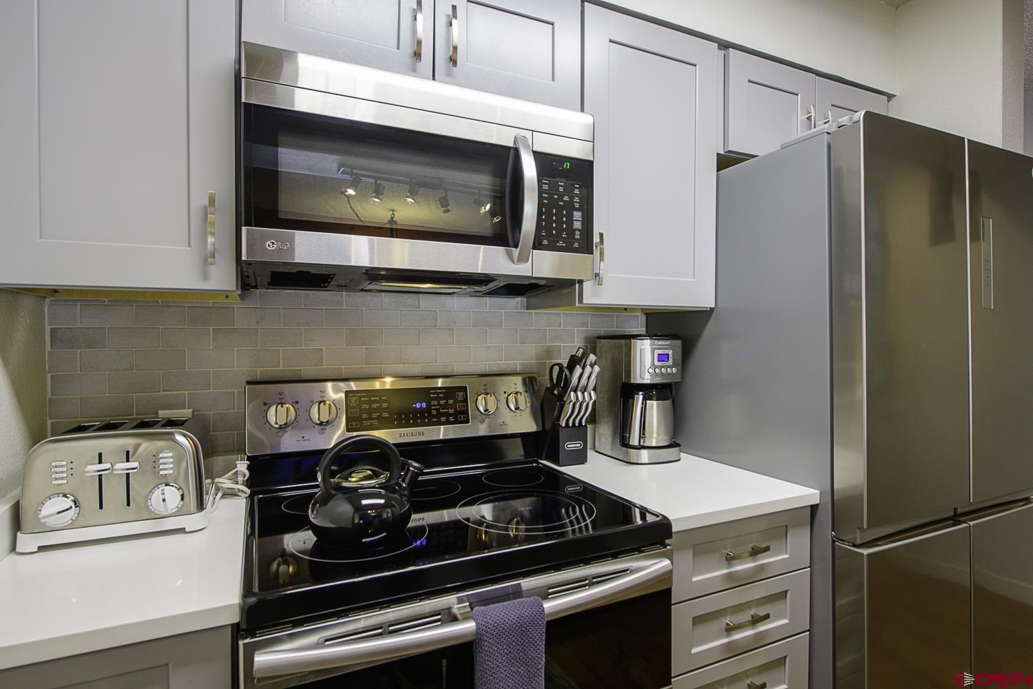 25 Emmons Road, Unit 37 Crested Butte, CO 81225 - Photo 11 of 28 a kitchen with stainless steel appliances granite countertop a stove and a microwave