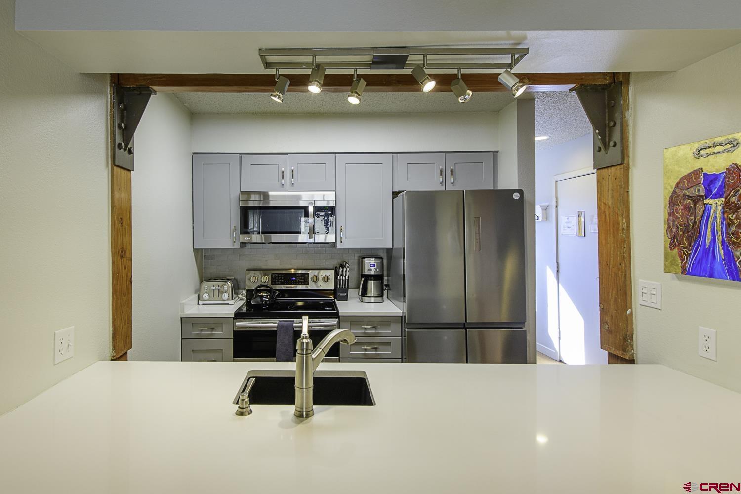 25 Emmons Road, Unit 37 Crested Butte, CO 81225 - Photo 10 of 28 a kitchen with stainless steel appliances a refrigerator and a stove top oven