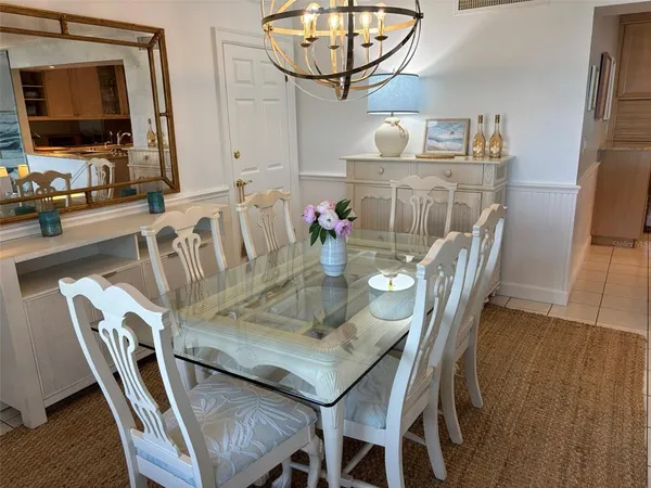 a view of a dining room with furniture a chandelier and wooden floor