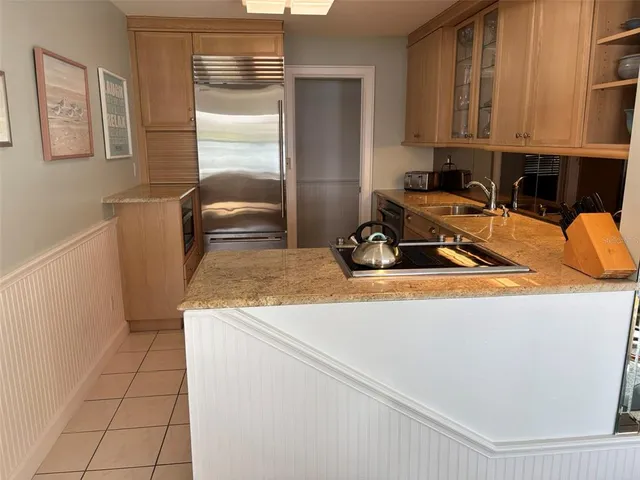 a view of a kitchen with a sink a refrigerator and cabinets