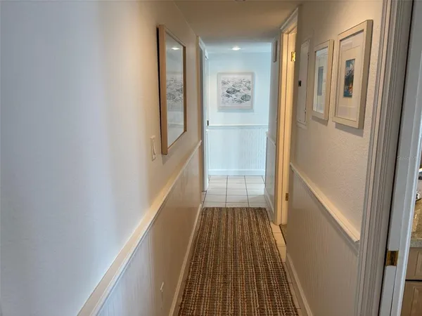 a view of a hallway with wooden floor and a bathroom