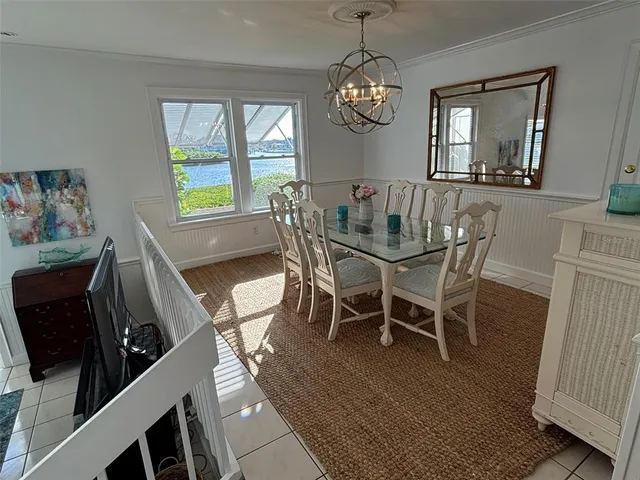 a view of a dining room with furniture a chandelier and wooden floor