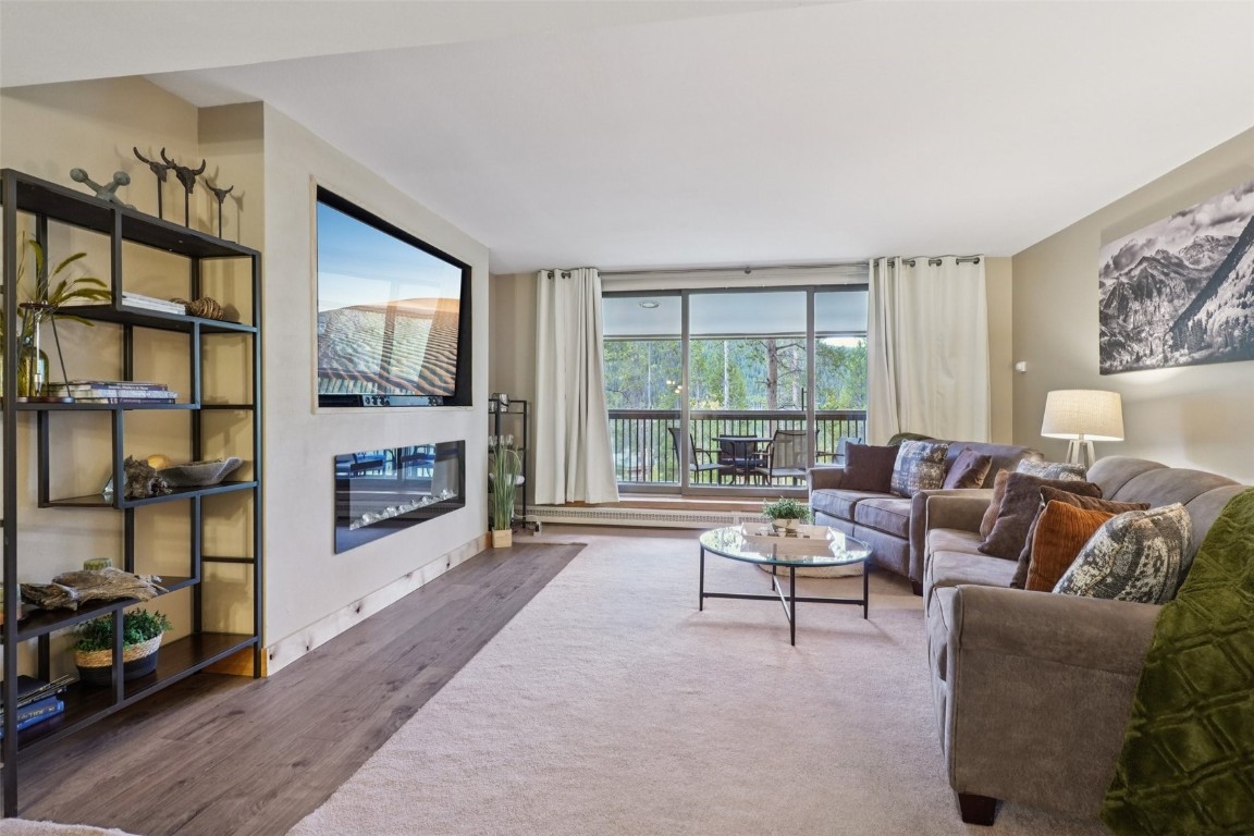 22097 Saints John Road, Unit 2506 Keystone, CO 80435 - Photo 6 of 47 Living area with wood finished floors and a glass covered fireplace