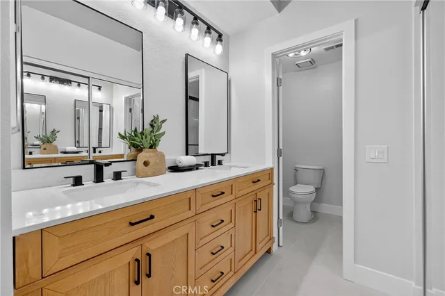 a bathroom with a granite countertop sink mirror and toilet