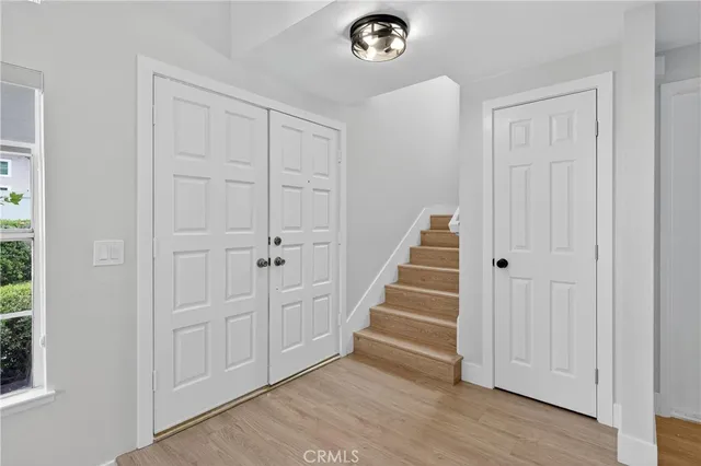 an empty room with wooden floor and entryway