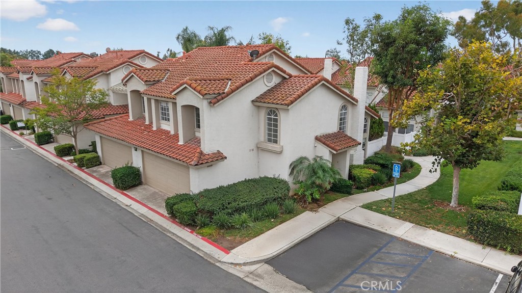 29 Carnation, Unit 64 Rancho Santa Margarita, CA 92688 - Photo 37 of 38 a front view of a house with a yard and potted plants