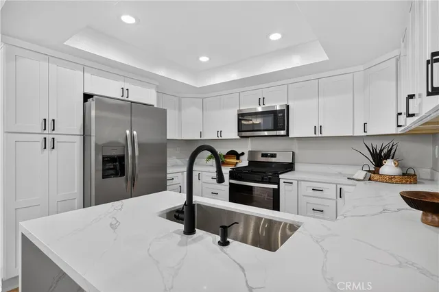 a kitchen with a refrigerator sink and white cabinets