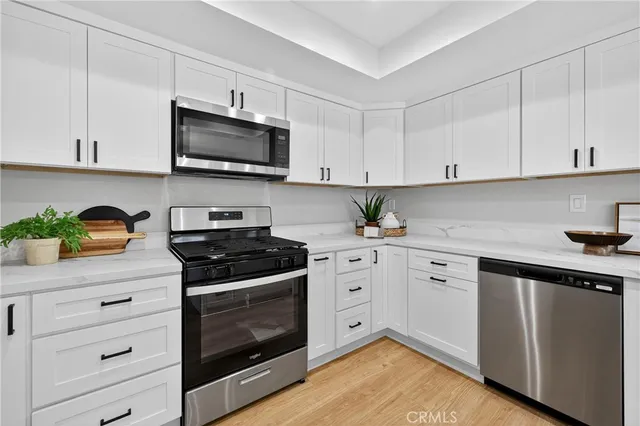 a kitchen with stainless steel appliances granite countertop a stove a sink and a microwave
