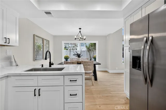 a kitchen with stainless steel appliances granite countertop a sink refrigerator and cabinets