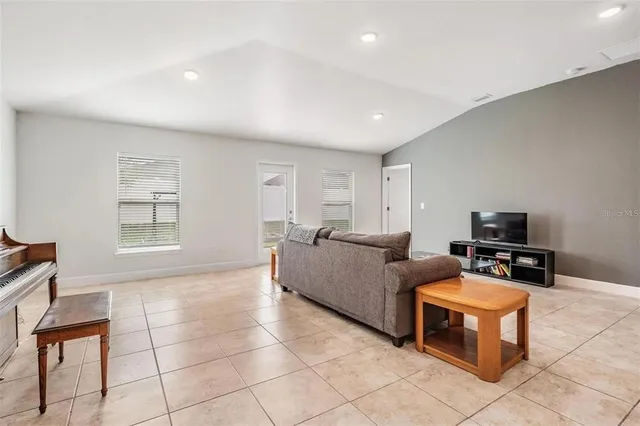 a living room with furniture a flat screen tv and a window