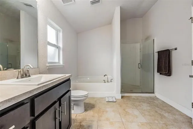 a bathroom with a granite countertop sink a toilet and bathtub