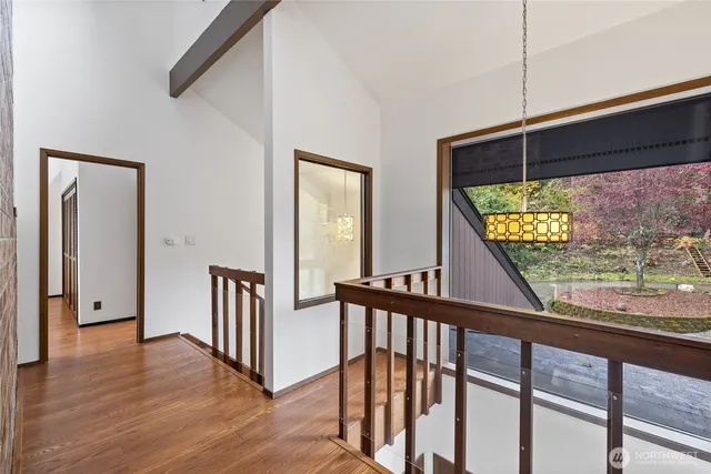 a view of a hallway with wooden floor and stairs