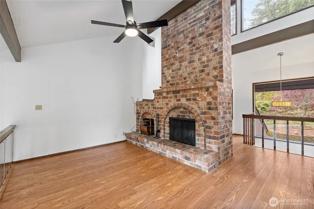 a view of empty room with wooden floor and fireplace
