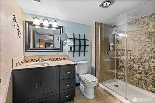 a bathroom with a sink a toilet and shower