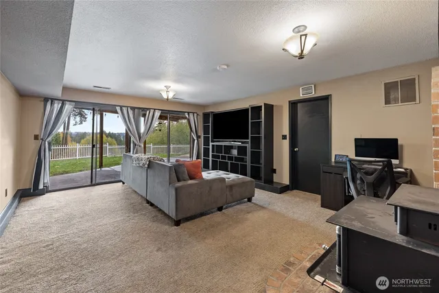 a living room with furniture tv and a floor to ceiling window