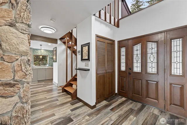 a view of a hallway with wooden floor and staircase