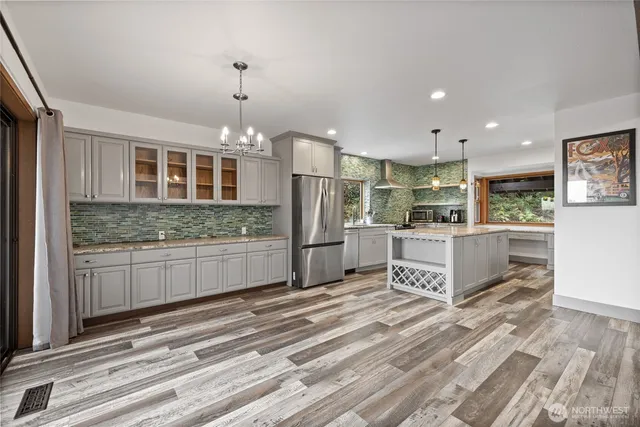 a large kitchen with kitchen island a sink stainless steel appliances and cabinets