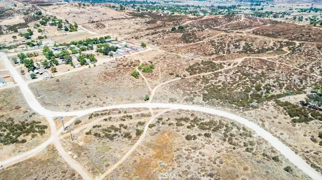 a view of a dry yard with wooden fence