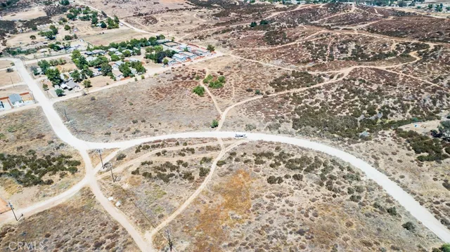 a view of a dry yard with trees