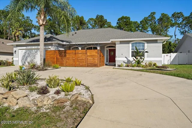 a living room with patio furniture and potted plants