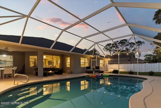 a view of a swimming pool with a lounge chairs in front of house