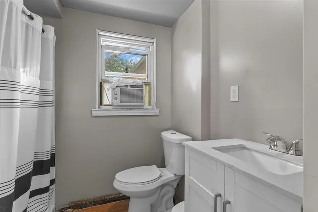 a bathroom with a sink toilet and window