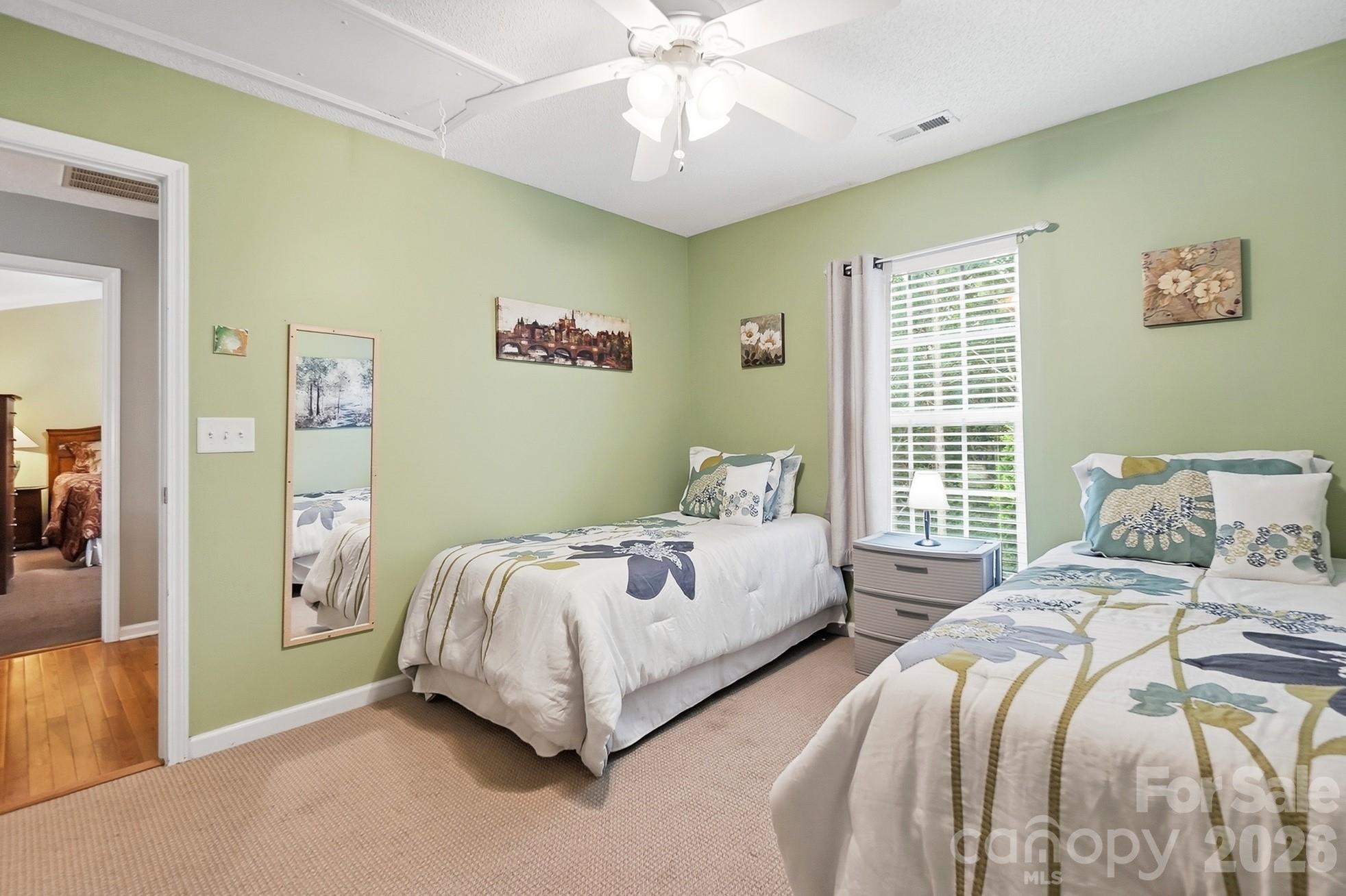 442 Sugar Maple Drive Tega Cay, SC 29708 - Photo 31 of 48 a bedroom with two beds and a chandelier