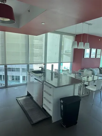 a kitchen with stainless steel appliances kitchen island granite countertop a table and chairs in it