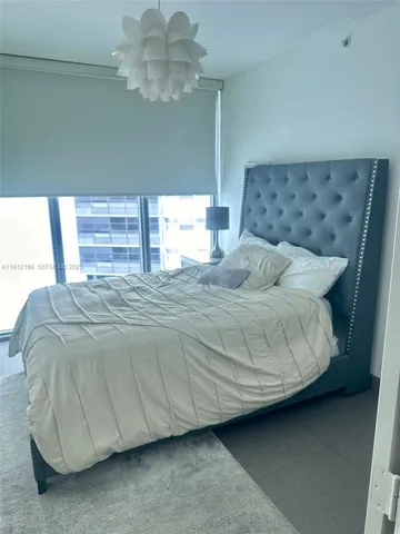 a bedroom with a bed and a chandelier