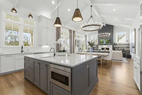 a dining room with wooden floor a chandelier a wooden table and chairs