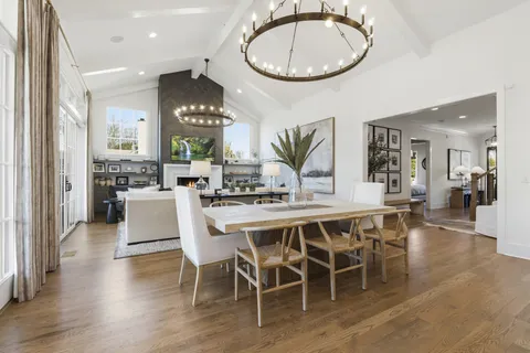 a living room with furniture a fireplace and a chandelier