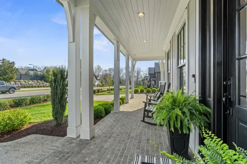 a view of a porch with couches and potted plants