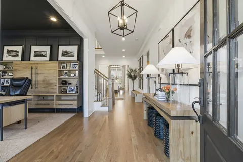a kitchen with stainless steel appliances kitchen island granite countertop a refrigerator a stove oven and white cabinets with wooden floor