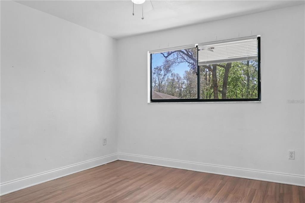 713 Southwest 69th Street Gainesville, FL 32607 - Photo 15 of 22 an empty room with wooden floor and a window