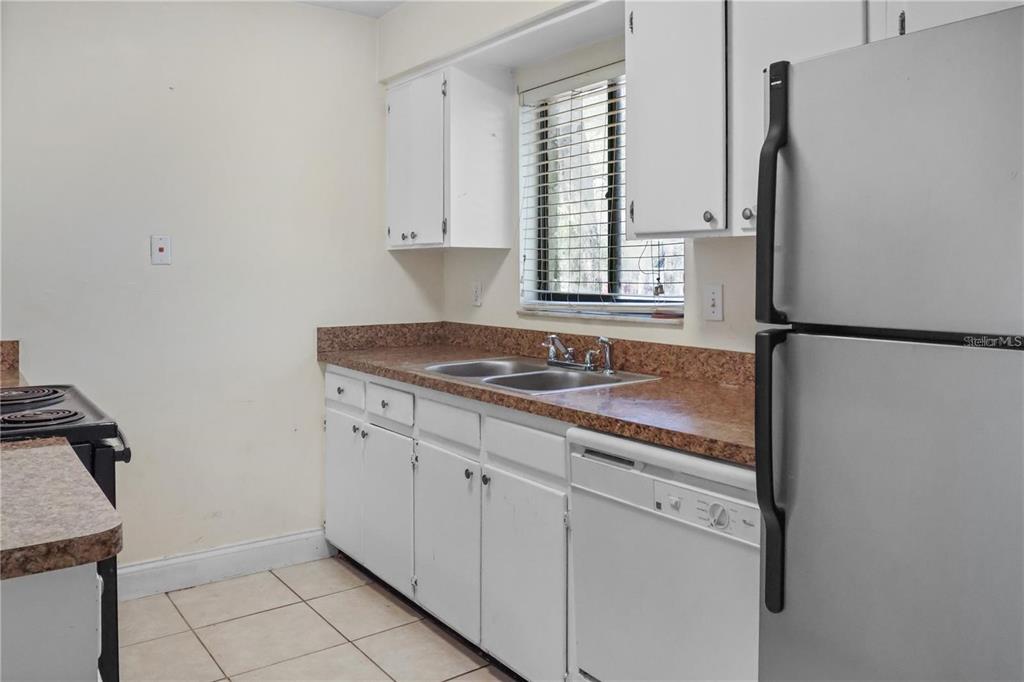 713 Southwest 69th Street Gainesville, FL 32607 - Photo 3 of 22 a kitchen with stainless steel appliances granite countertop a sink stove and refrigerator