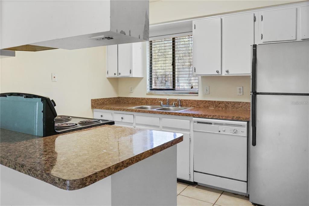 713 Southwest 69th Street Gainesville, FL 32607 - Photo 4 of 22 a kitchen with stainless steel appliances granite countertop a sink stove and refrigerator