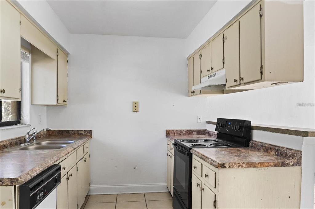 713 Southwest 69th Street Gainesville, FL 32607 - Photo 9 of 22 a kitchen with granite countertop a sink and a stove