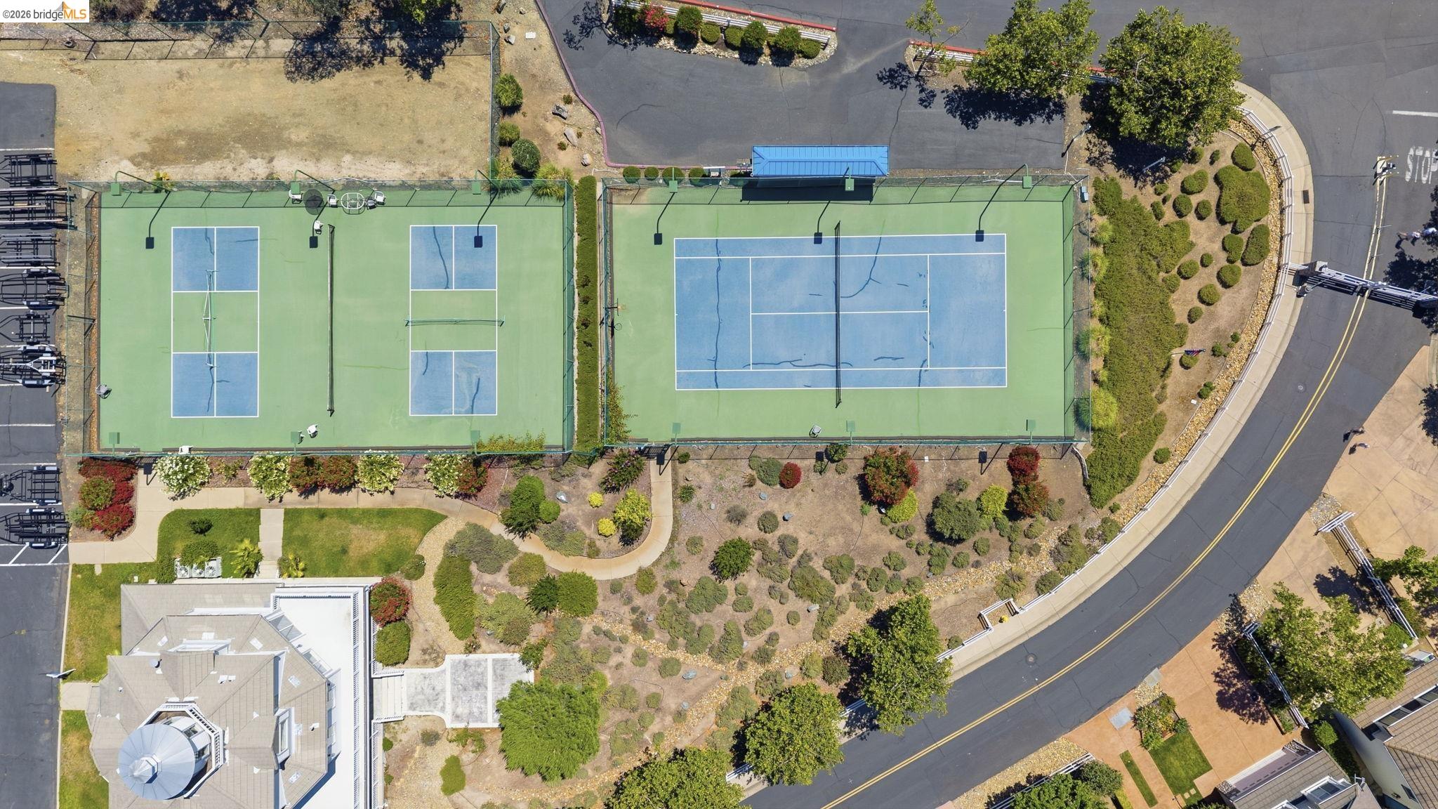 6242 Bluff View Road Copperopolis, CA 95228 - Photo 57 of 59 Recreational amenities featuring two pickleball courts and one tennis court, bordered by landscaped areas and paved pathways