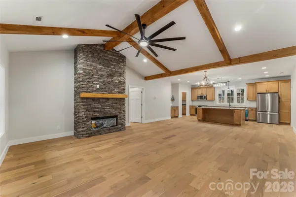 a view of an empty room with a fireplace and a fan