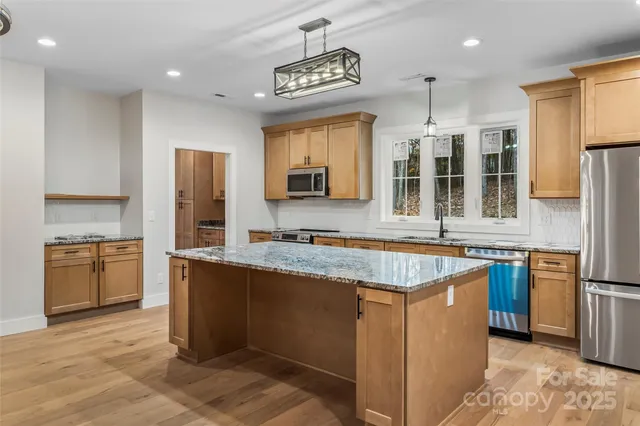 a kitchen with stainless steel appliances granite countertop a sink stove and refrigerator